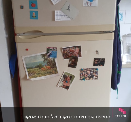 מקרר עם מגנטים ותמונות על הדלת